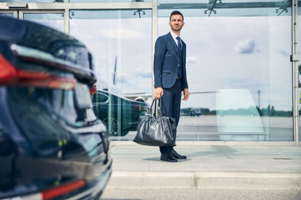 Elegant Businessman Waiting For A Shuttle Bus Near The Airport