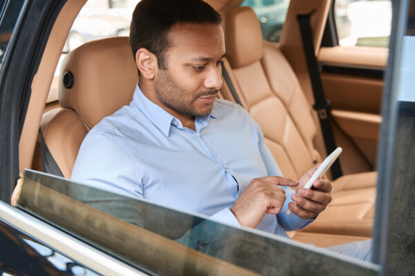 Passenger Using His Cellphone In Car Cabin