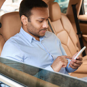 Passenger Using His Cellphone In Car Cabin