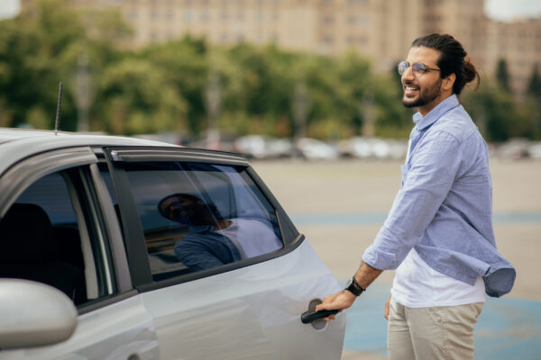 Cheerful Middle Eastern Man In Casual Getting In Taxi